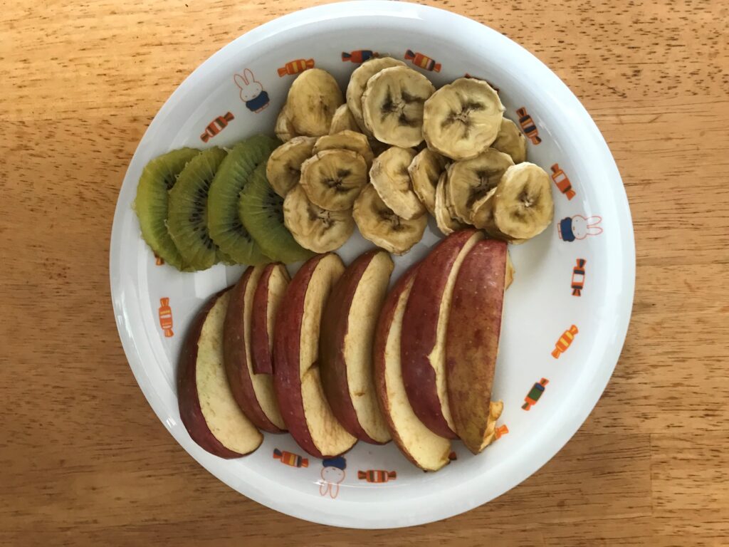 バナナとリンゴとキウイのドライフルーツを1つの皿の上に載っている