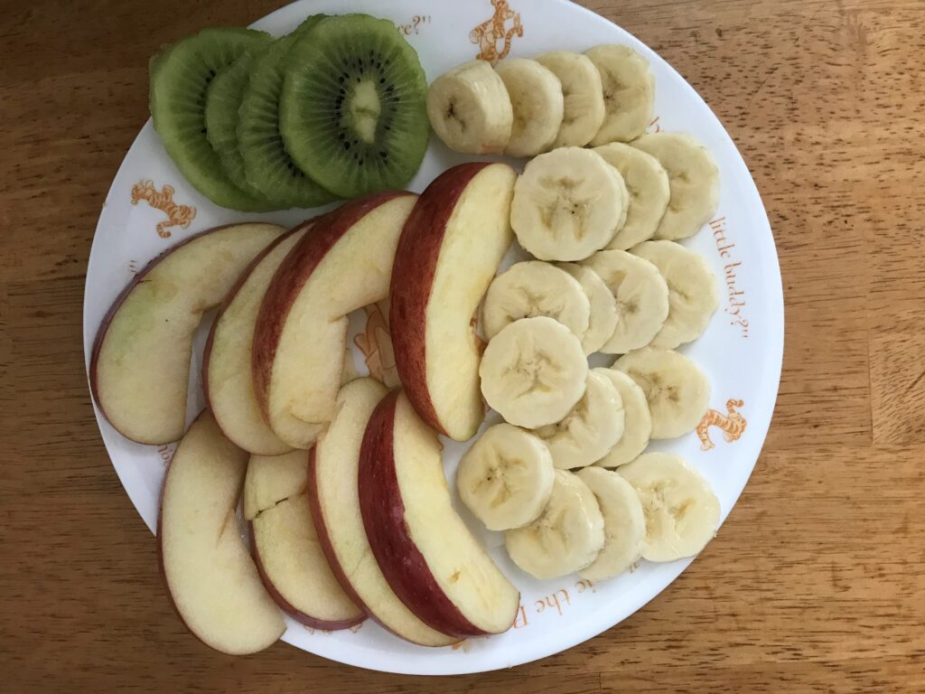 バナナとリンゴとキウイを細かく切っている
